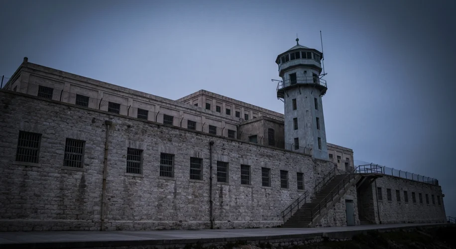 A stern, imposing exterior shot of Alcatraz Federal Penitentiary, emphasizing its thick walls and ba
