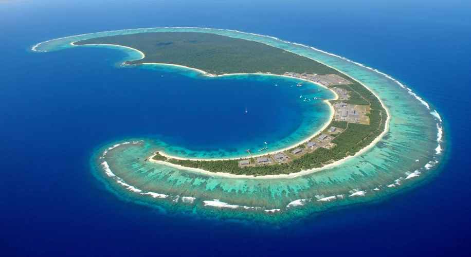 An aerial view of Diego Garcia, showing the crescent-shaped island with its lagoon, surrounded by th