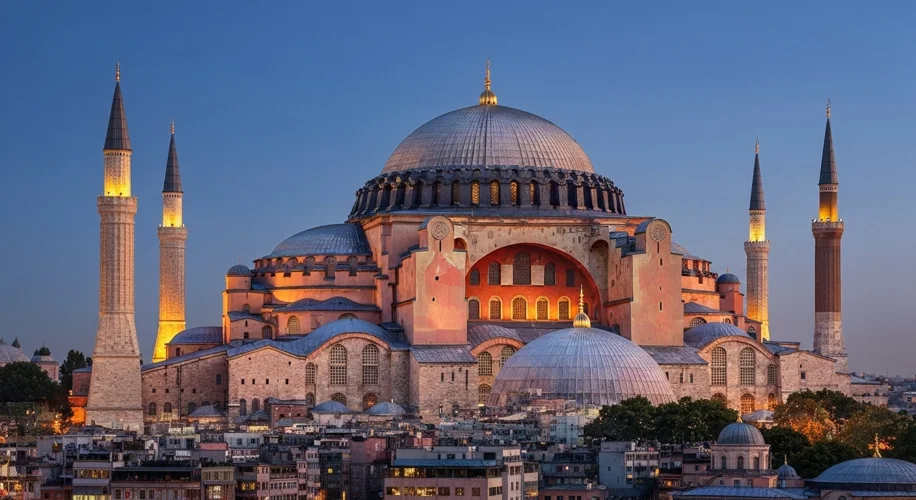 The Hagia Sophia in Istanbul, illuminated at dusk, with minarets added to its iconic dome. Below, a 